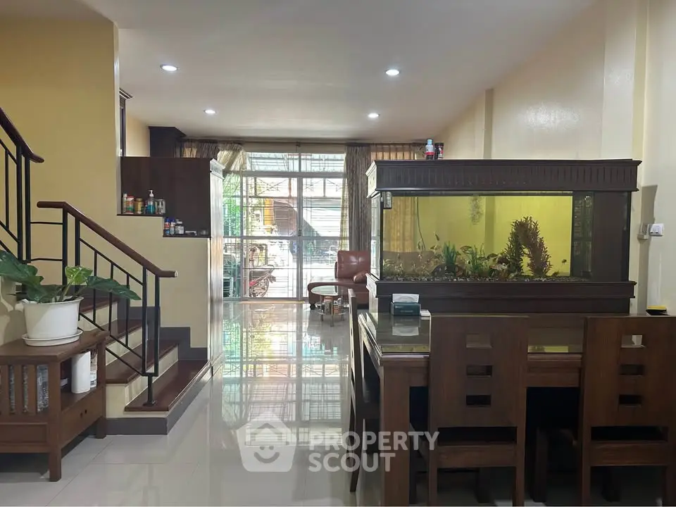 Spacious living room with elegant wooden furniture and a large aquarium, perfect for relaxation.