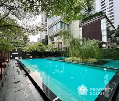 Luxurious condominium with stunning outdoor pool and lush greenery in urban setting.