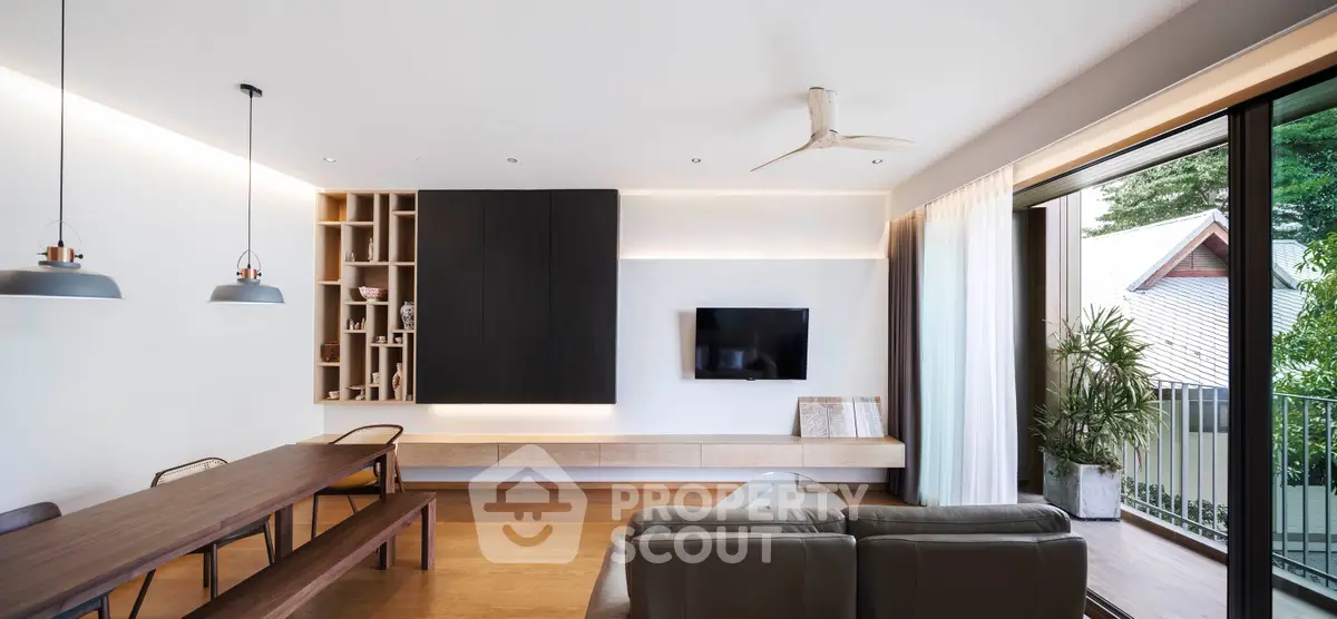 Modern living room with open layout, stylish furniture, and balcony access in a contemporary home.