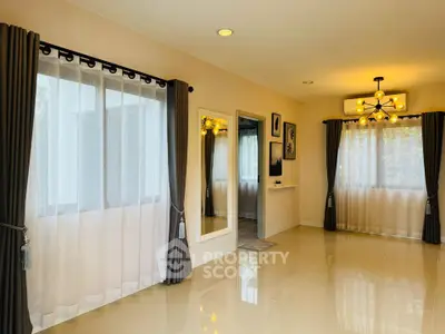 Spacious and elegant living room with large windows and modern lighting
