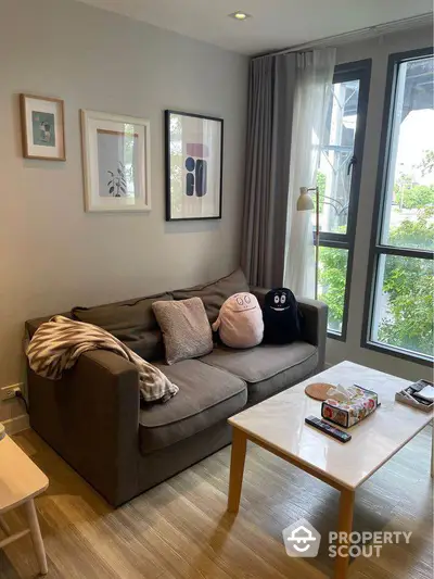 Cozy living room with plush sofa and large windows offering natural light