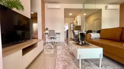 Modern living room with sleek furniture and open layout, featuring a cozy workspace and stylish decor.