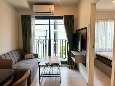 Modern living room with balcony access and stylish decor in a cozy apartment.