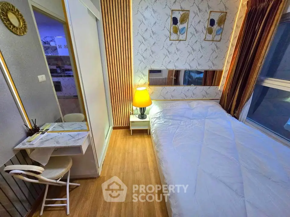 Cozy bedroom with modern decor and natural light, featuring a stylish desk and comfortable bedding.