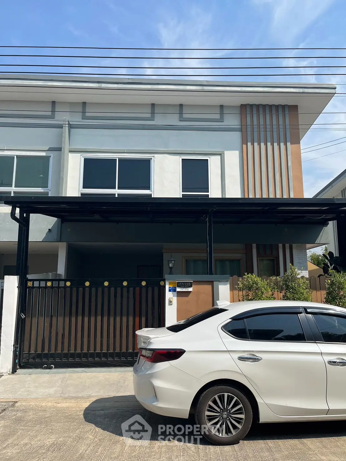 Modern two-story house with sleek design and car parked in driveway