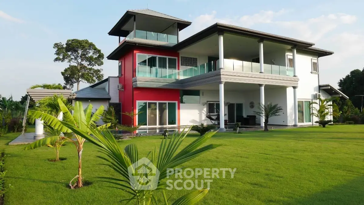 Stunning modern house with lush green lawn and spacious balcony, perfect for luxurious living.