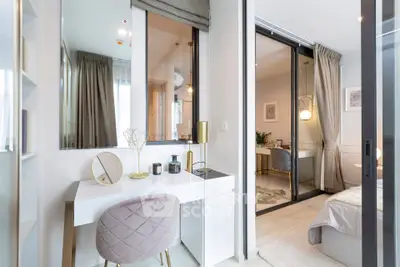 Modern bedroom with elegant vanity and sliding glass doors leading to a cozy study area.