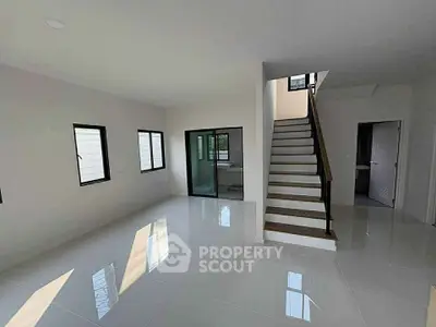 Spacious modern living room with sleek staircase and large windows
