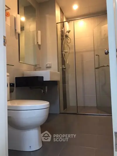 Modern bathroom with glass shower and sleek fixtures in a contemporary apartment.