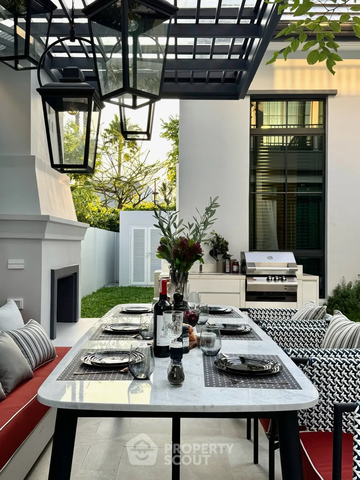 Luxurious outdoor dining area with elegant table setting and modern grill, perfect for entertaining.