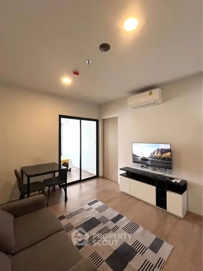 Modern living room with sleek furniture and air conditioning, featuring a cozy dining area and stylish decor.