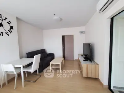 Modern living room with sleek furniture and wall clock, featuring a cozy dining area.
