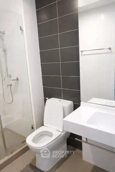 Modern bathroom with sleek design featuring a glass shower and contemporary fixtures.