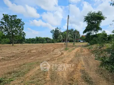 Expansive plot of land with trees and clear skies, ideal for development.