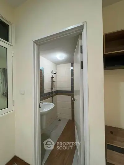 Compact bathroom with modern fixtures and neutral tiles, perfect for efficient space utilization.