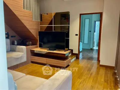 Modern living room with wooden flooring and stylish furniture in a cozy apartment.