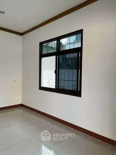 Spacious room with large window and glossy tiled floor