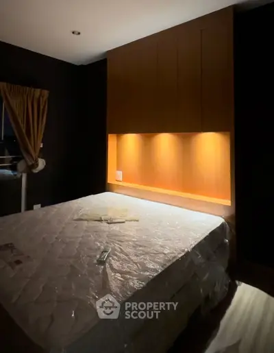 Cozy bedroom with ambient lighting and a comfortable bed, perfect for relaxation and rest.