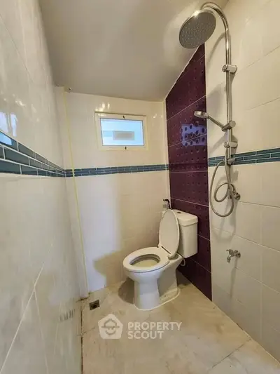 Modern bathroom with shower and toilet, featuring stylish tile design.