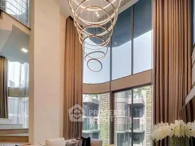 Luxurious living room with high ceilings and modern chandelier in upscale apartment.