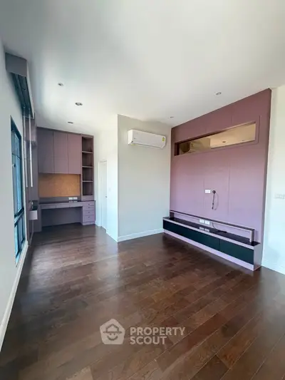 Spacious modern living room with built-in storage and hardwood floors
