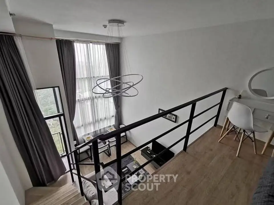 Modern loft apartment with high ceilings and stylish decor, featuring a mezzanine and large windows.