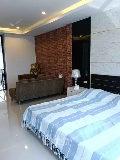 Modern bedroom with cozy seating area and stylish decor