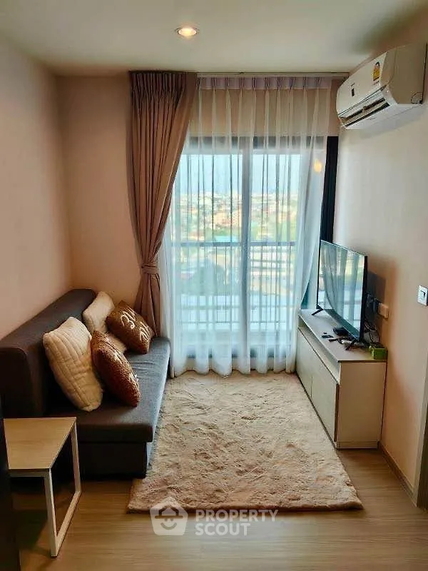 Cozy living room with modern decor and large window offering a scenic view.