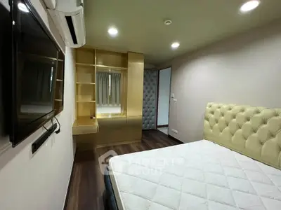Modern bedroom with built-in storage and wall-mounted TV, featuring elegant lighting and plush headboard.