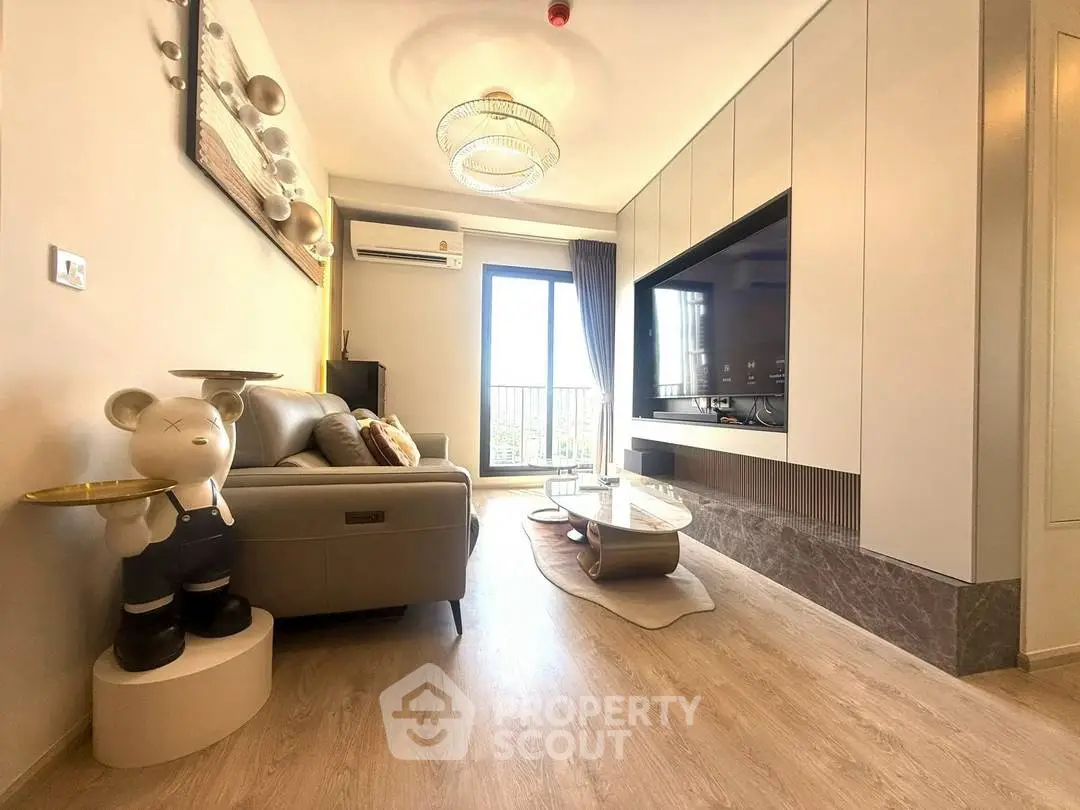 Modern living room with stylish decor and large TV, featuring elegant lighting and balcony view.