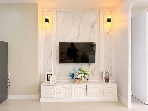 Elegant living room with marble accent wall and modern TV setup