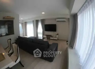 Spacious living room with modern decor and large windows for natural light.