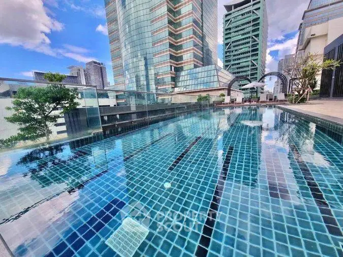 Luxurious rooftop pool with stunning cityscape views in modern high-rise building.
