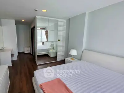 Spacious modern bedroom with mirrored wardrobe and elegant decor