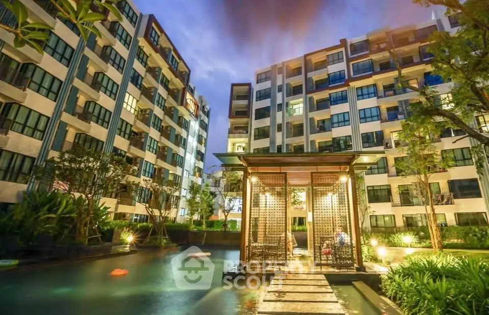 Luxurious condominium exterior with serene pool and lush garden at twilight, perfect for modern living.