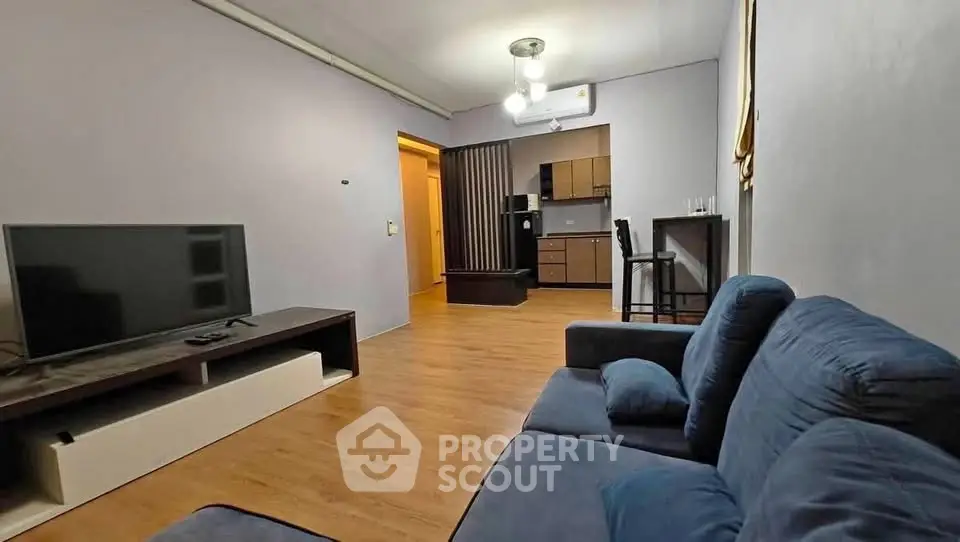 Spacious living room with modern decor and open kitchen layout, perfect for entertaining.