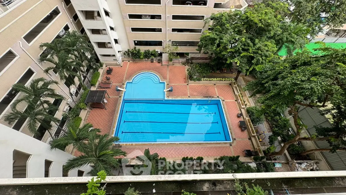 Stunning aerial view of a luxurious residential swimming pool surrounded by lush greenery and modern architecture.