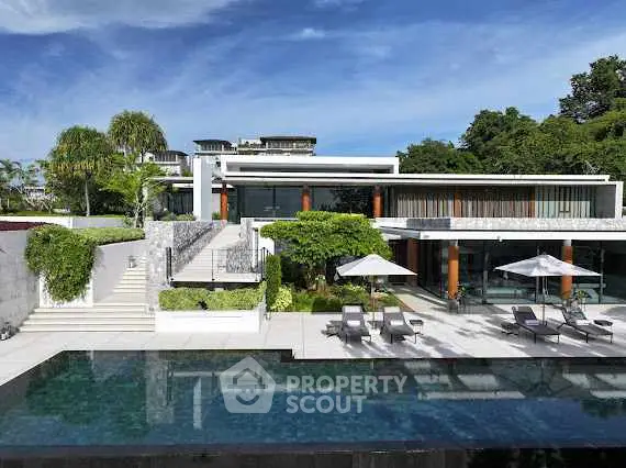 Luxurious modern villa with pool and lush greenery, perfect for upscale living.