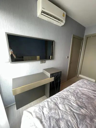 Modern bedroom with sleek furniture and air conditioning unit, perfect for comfortable living.