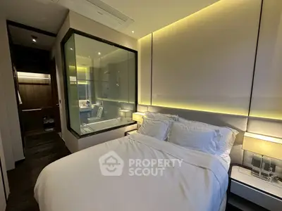 Luxurious modern bedroom with glass-enclosed bathroom and ambient lighting