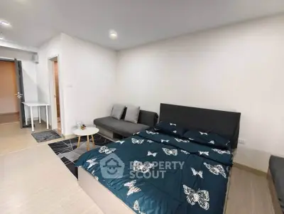 Modern bedroom with stylish decor and cozy seating area, perfect for relaxation and comfort.