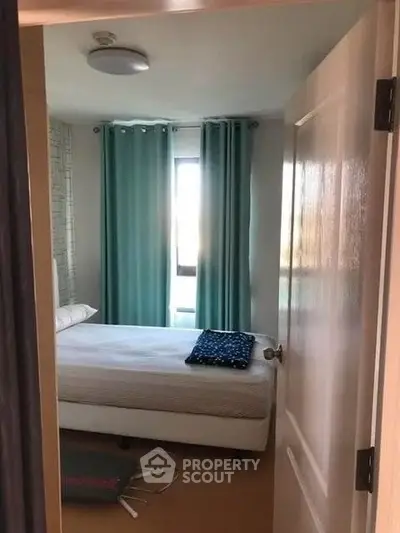 Cozy bedroom with teal curtains and a comfortable bed, perfect for relaxation.