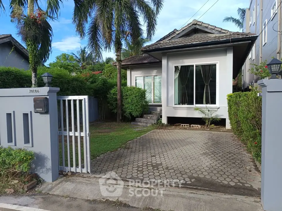 Charming single-story house with lush garden and gated driveway in a serene neighborhood.