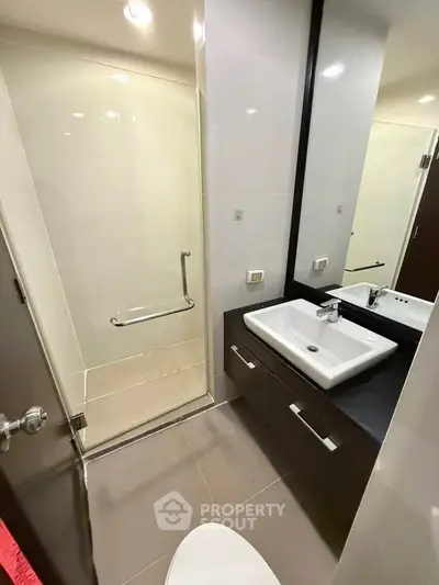 Modern bathroom with sleek design featuring a glass shower and stylish vanity.