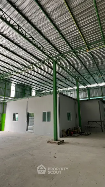 Spacious industrial warehouse with high ceilings and ample natural light.