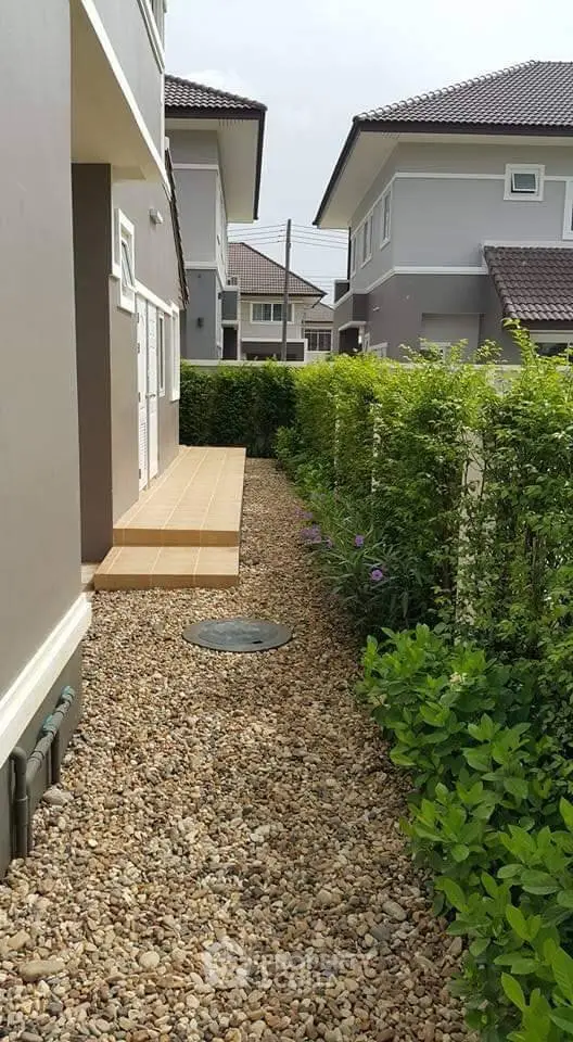 Charming suburban home with lush garden and pebble pathway, ideal for tranquil living.