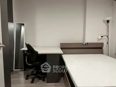 Modern minimalist bedroom with sleek desk and comfortable chair, perfect for a cozy living space.