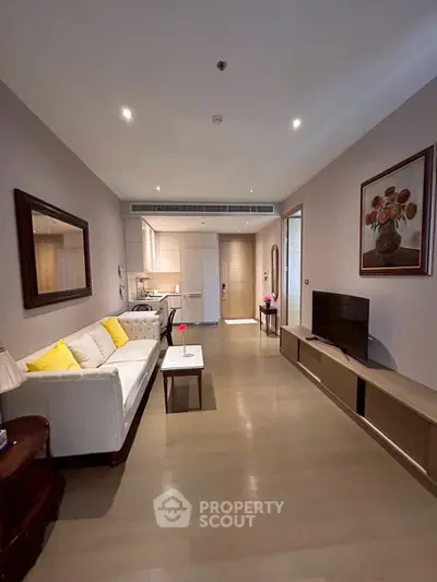 Modern living room with sleek design and cozy ambiance, featuring a white sofa and wall art.