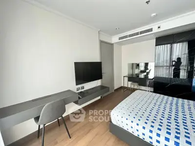 Modern bedroom with sleek furniture and wall-mounted TV in a stylish apartment.