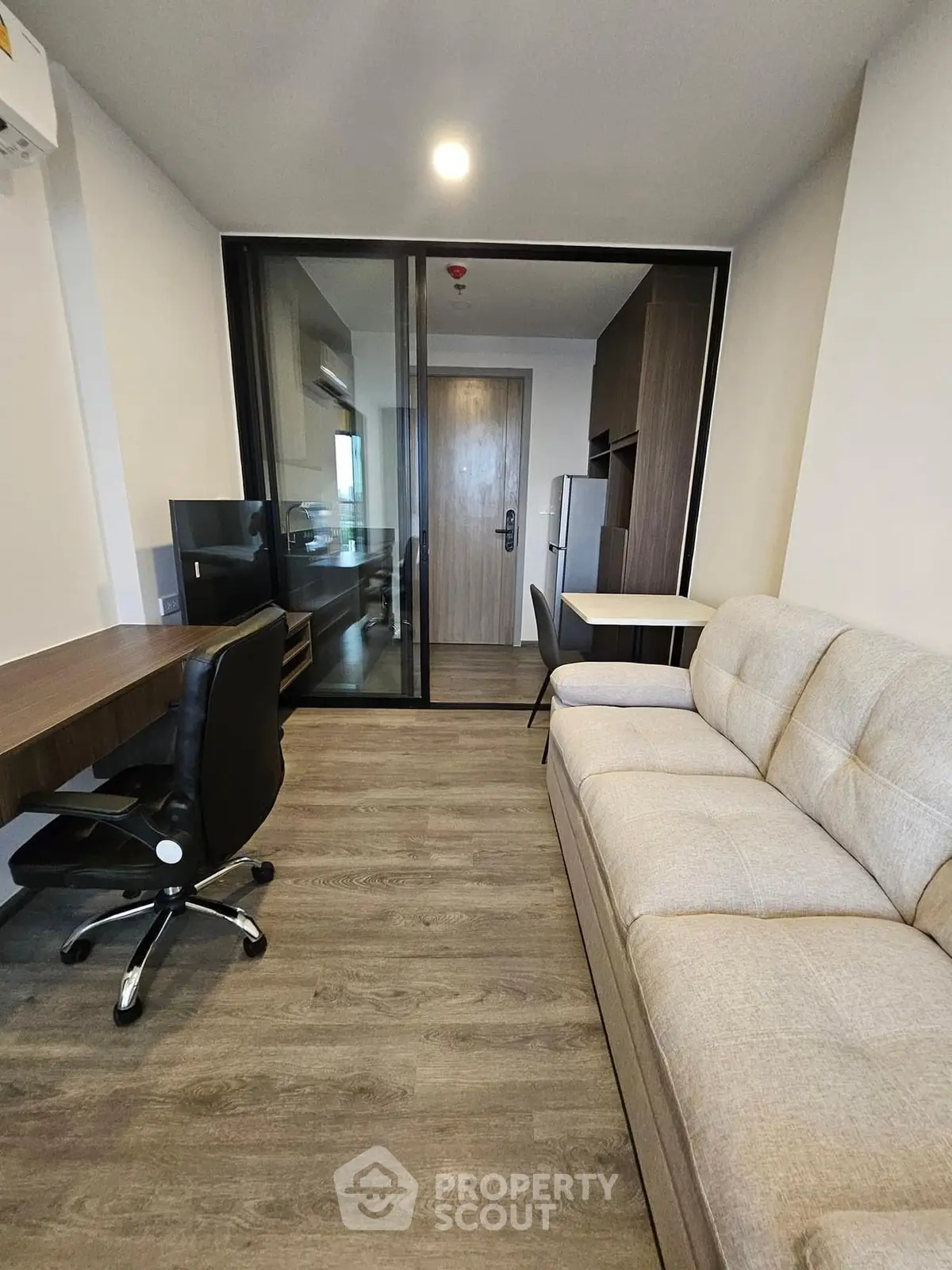 Modern living room with sleek furniture and glass partition in a stylish apartment.
